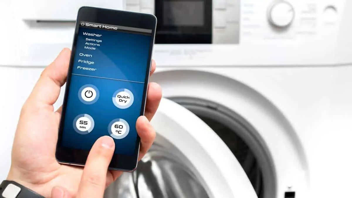 man uses smartphone for washing machine