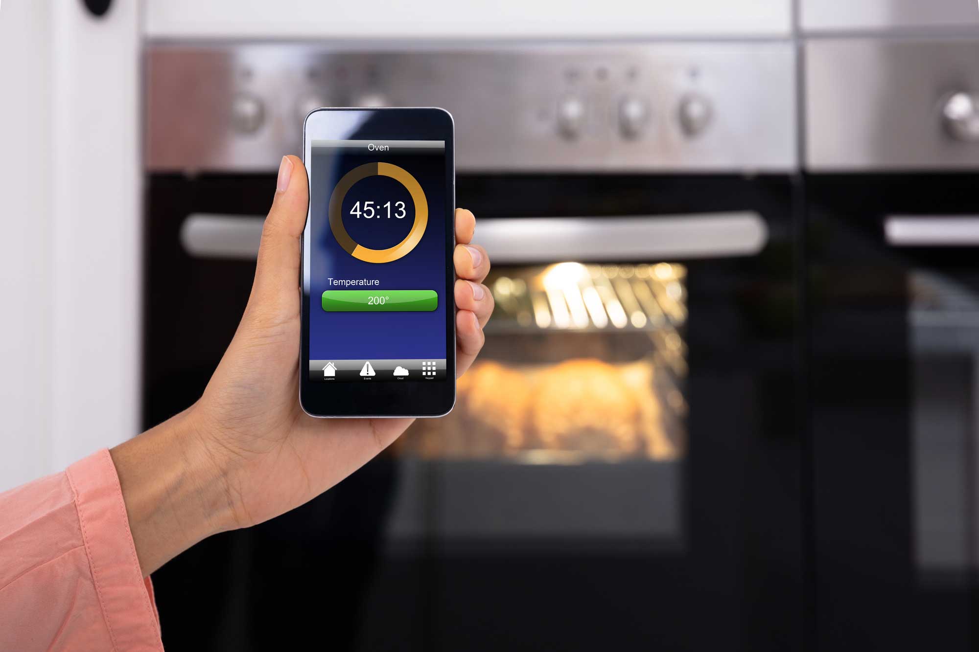 lady controlling smart oven with smart phone